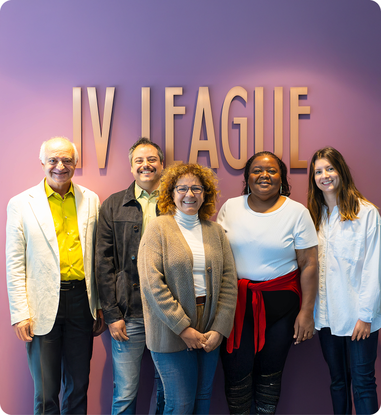 Group of five diverse medical professionals standing in front of IV LEAGUE sign